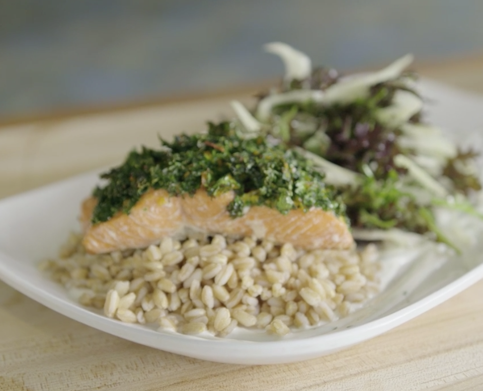 kale crusted salmon on a bed of farro and with salad beside